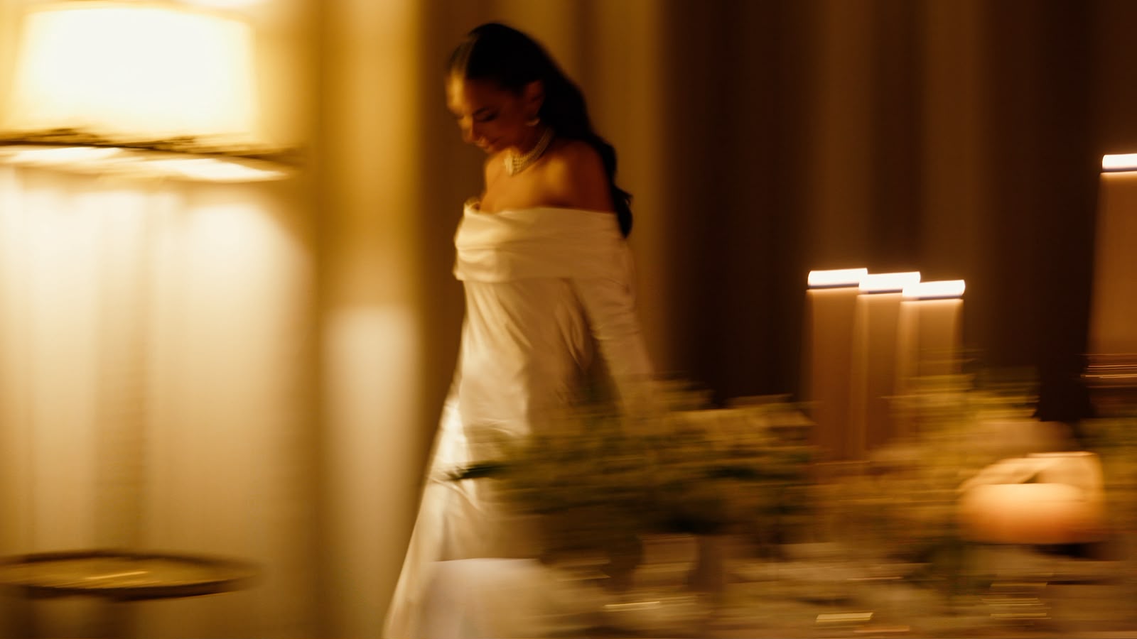 Bride walking through warm candlelight